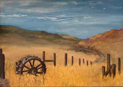 Old wooden fence and wheel in a field of golden hay